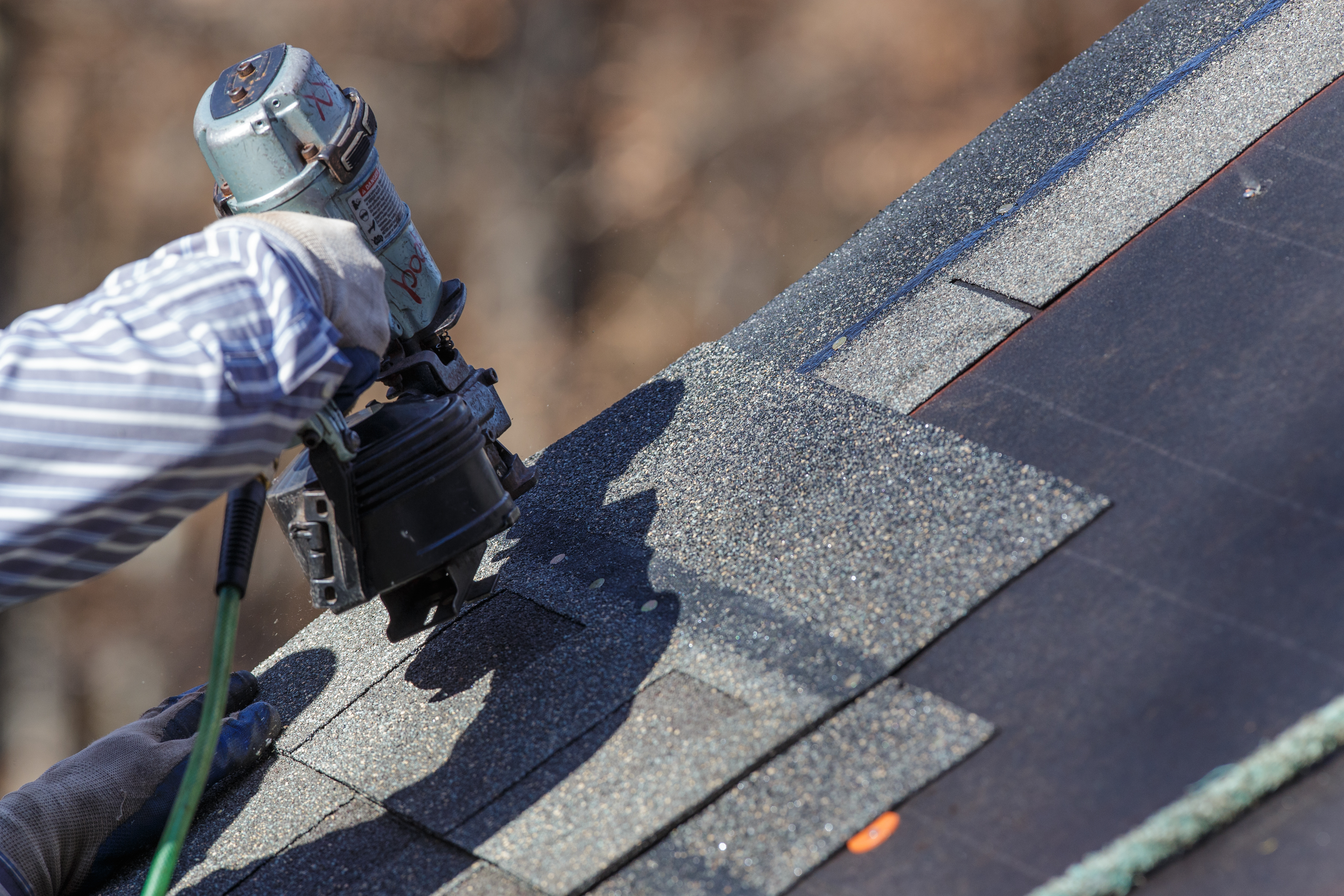 Roofing leads contractor roofing nail gun on asphalt shingles